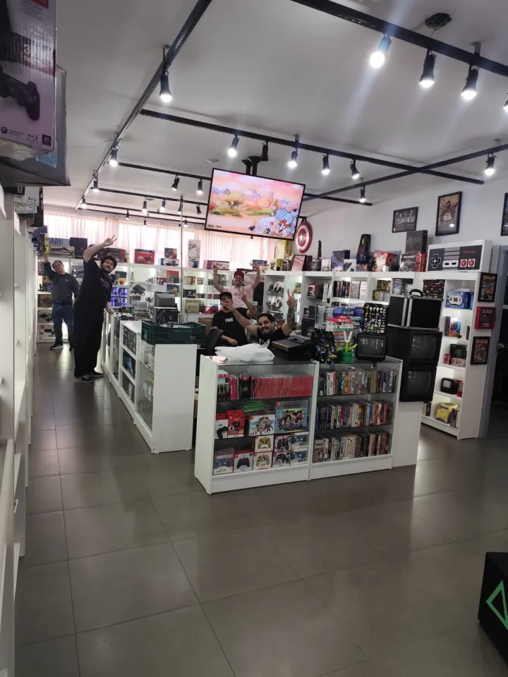 Equipe reunida entre os consoles e vitrines da Retroteka.